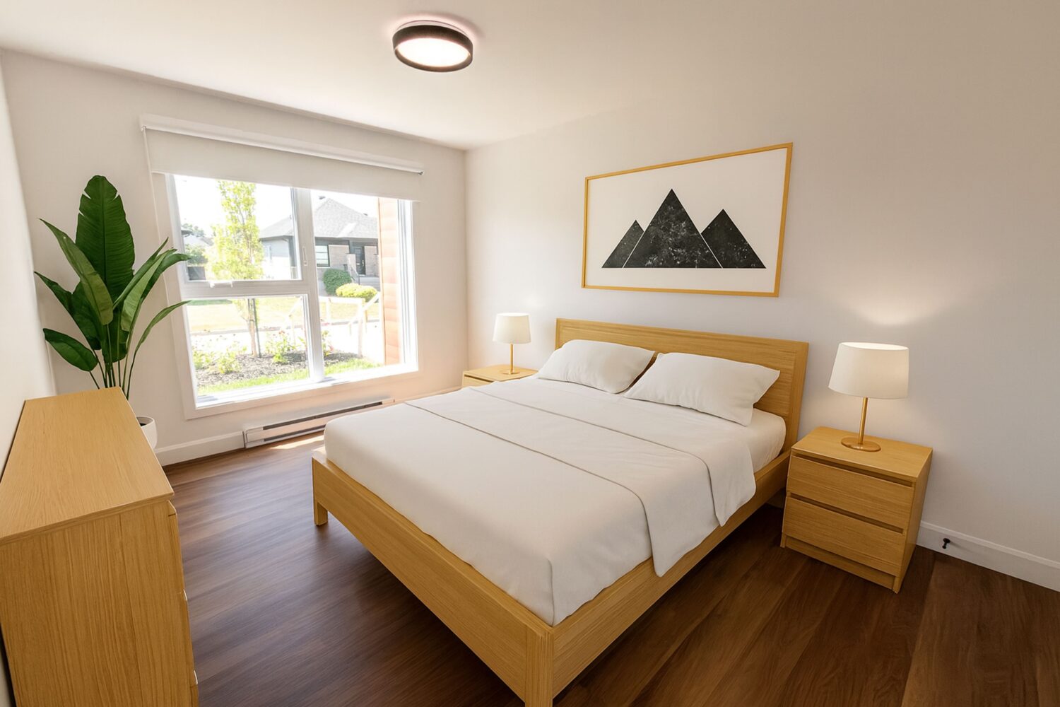 Vue d'une chambre à coucher lumineuse et moderne avec des murs blancs et un plancher en bois. La chambre est meublée d'un lit avec une literie blanche, de deux tables de chevet en bois clair avec des lampes, et d'une commode assortie. Une grande fenêtre donne sur un quartier résidentiel. Un grand tableau avec une illustration minimaliste de montagnes est accroché au mur au-dessus du lit.